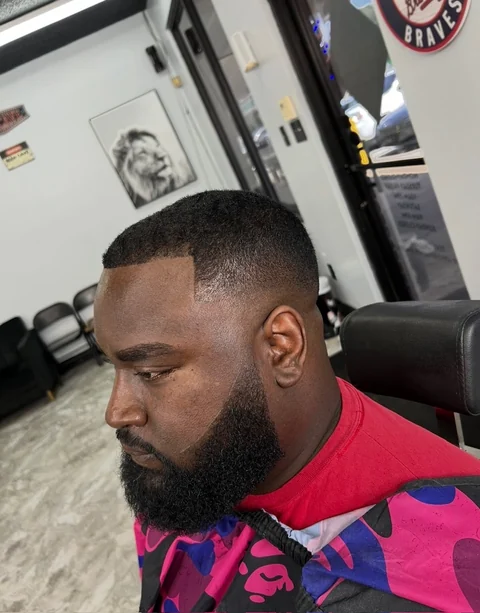 Client with a sharp line-up, taper fade and a full, shaped beard