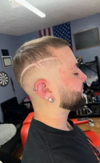 Client with a textured top, skin fade and two curved lines shaved into the side