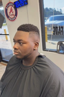 Client with a short textured top, high skin fade and a shaved part line